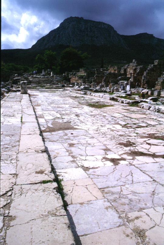 Strada lastricata negli scavi di Corinto e Acrocorinto sullo sfondo